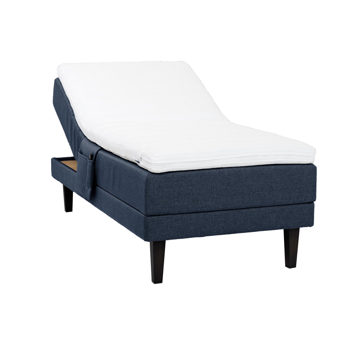 Sininen Hilding Feel Ergo -moottorisänky 90 x 200 cm hiilenmustilla 23 cm korkeilla Royal -tammijaloilla ja Hilding Ergo -sijauspatjalla. Kuvan tarviketasku myydään erikseen.