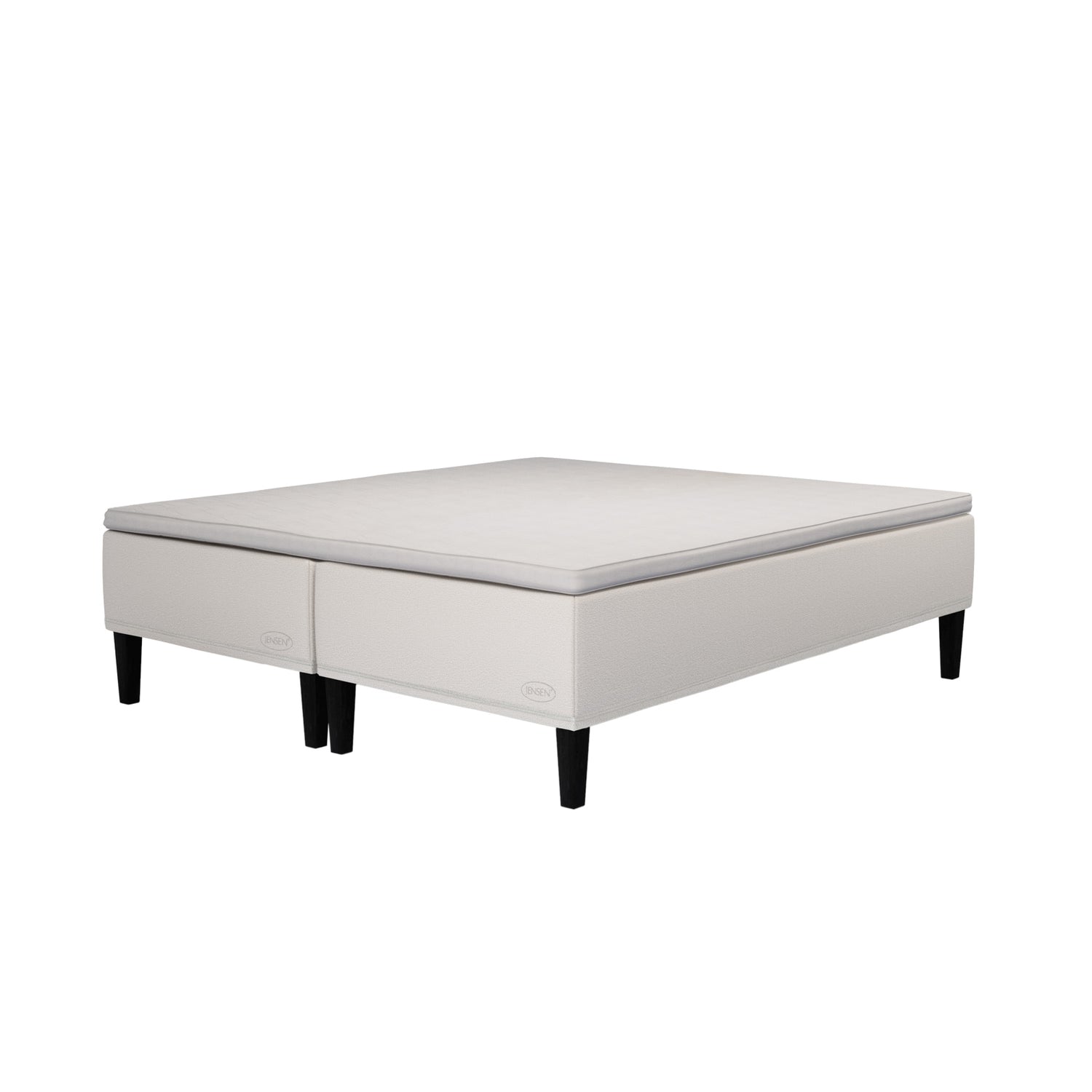 Jensen Carat -runkopatjasängyn beige verhoiluväri ja nelikulmaiset 23 cm korkeat mustat tammijalat. Yhtenäinen TempSmart -sijauspatja ja jalat sisältyvät hintaan.