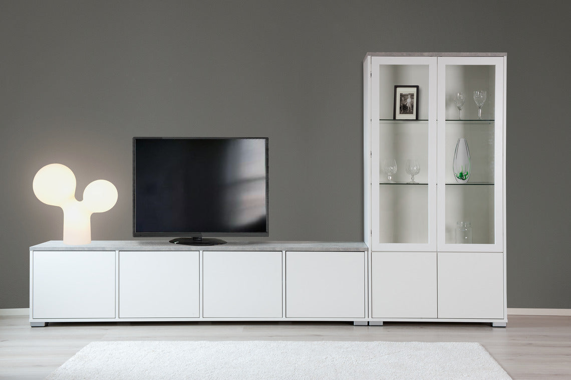 Kivi-malliston kalusteista saa helposti koottua yhtenäisen kokonaisuuden. Kuvassa neljän ovikaapin Kivi-tv-taso ja Kivi-vitriini valkoisina, harmaalla betonijäljitelmän värisellä kannella.