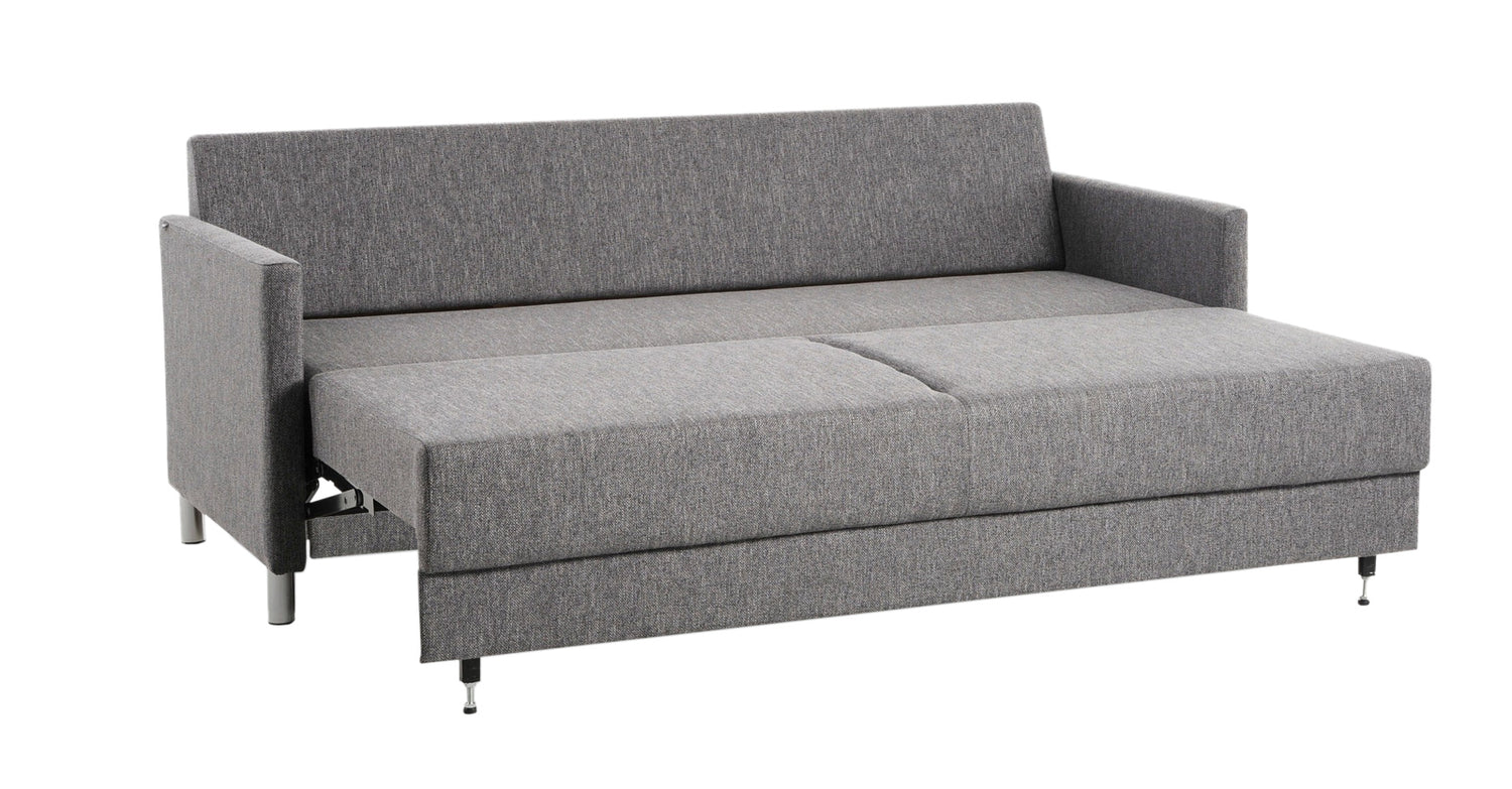 Lilja-vuodesohva antrasiitin värisellä Verde 19 -kankaalla. Kuvassa sohvan vuodemekanismi on avattuna, vuodekoko 188 x 133 cm. Kuvan sohva on poikkeuksellisesti kuvattu vakiona sohvaan kuuluvien mustien puujalkojen sijaan 10 cm korkeilla metallijaloilla.