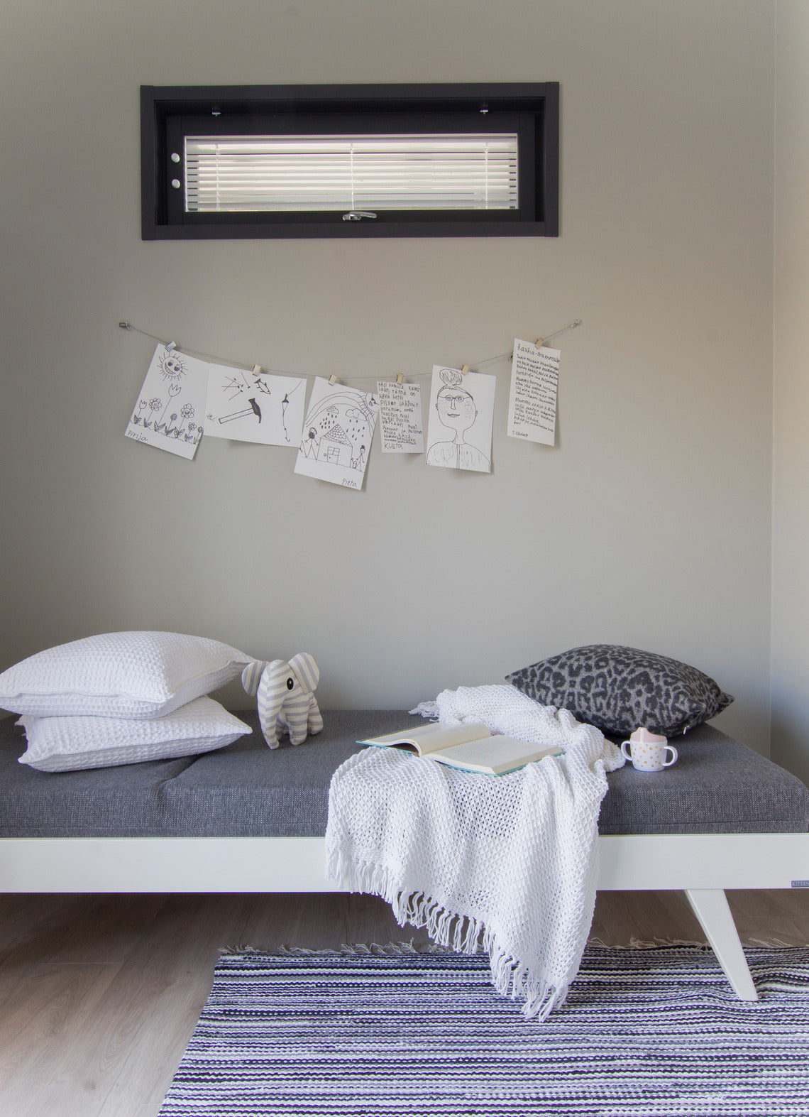 Divaanirakenteinen Notte-puusohva valkoisella rungolla ja harmaalla Levon-taittopatjasarjalla. Patjasarja myydään erikseen.