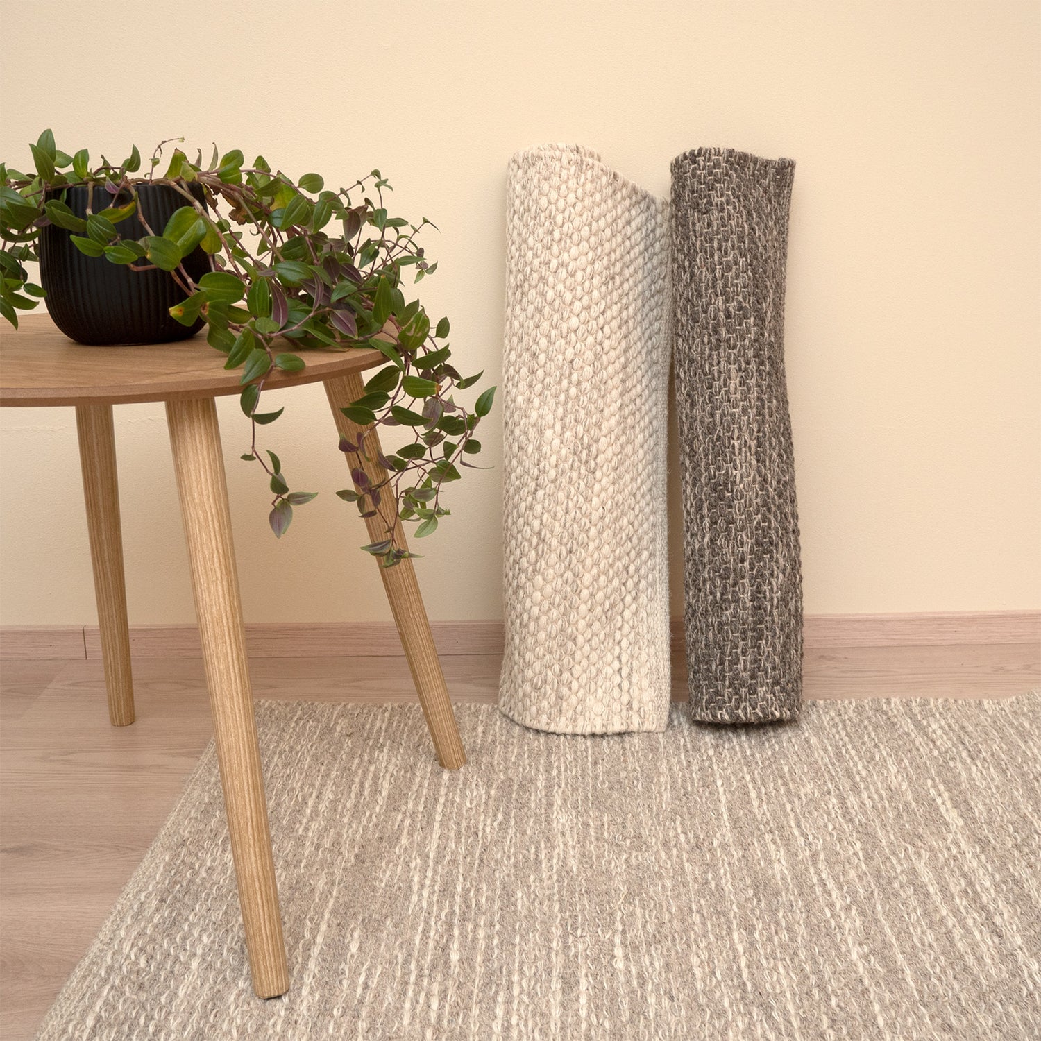 Käsinkudottu villamatto Oona tuo sisustukseen lämpöä. Mattoa on saatavana luonnollisen pehmeissä sävyissä luonnonvalkoisena, tummanharmaana ja harmaana, joka on kuvassa levitettynä lattialle.