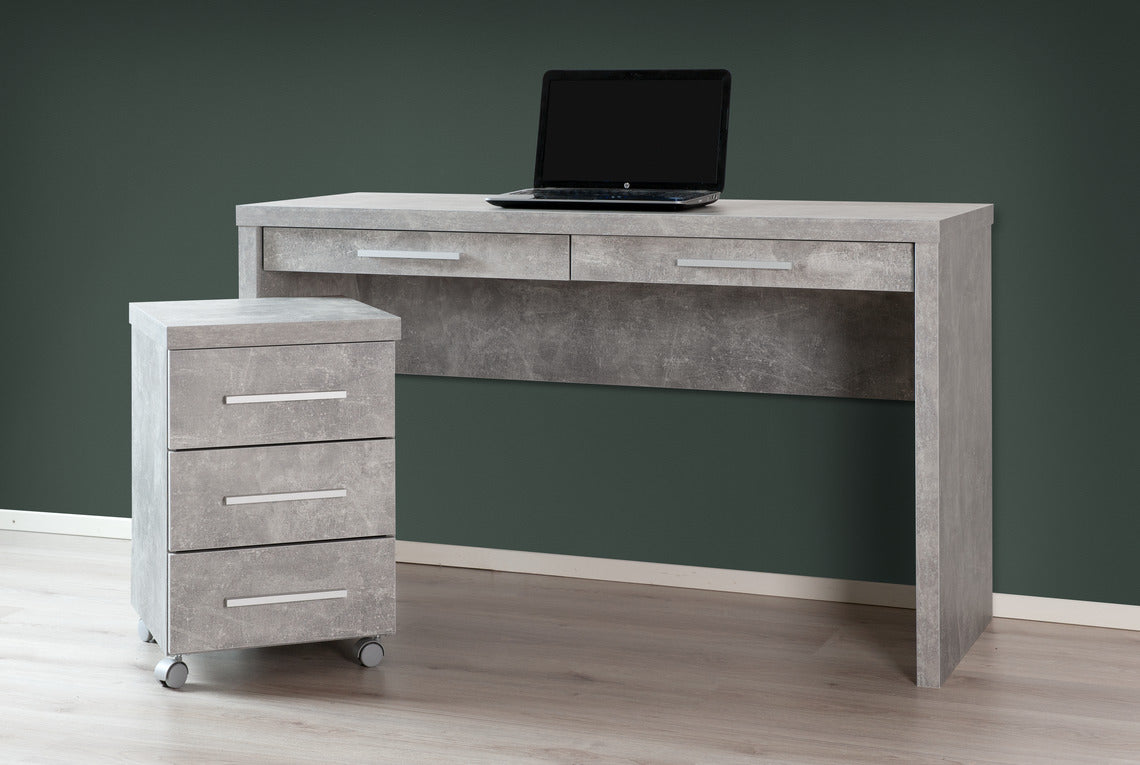 Shape-sarjan leveä työpöytä laatikoilla, sekä laatikosto. Kuvan työpisteen kalusteet ovat harmaan betoninvärisiä.