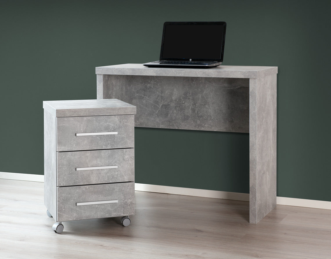 Shape-sarjan kapea työpöytä, sekä laatikosto. Kuvan työpisteen kalusteet ovat harmaan betoninvärisiä.