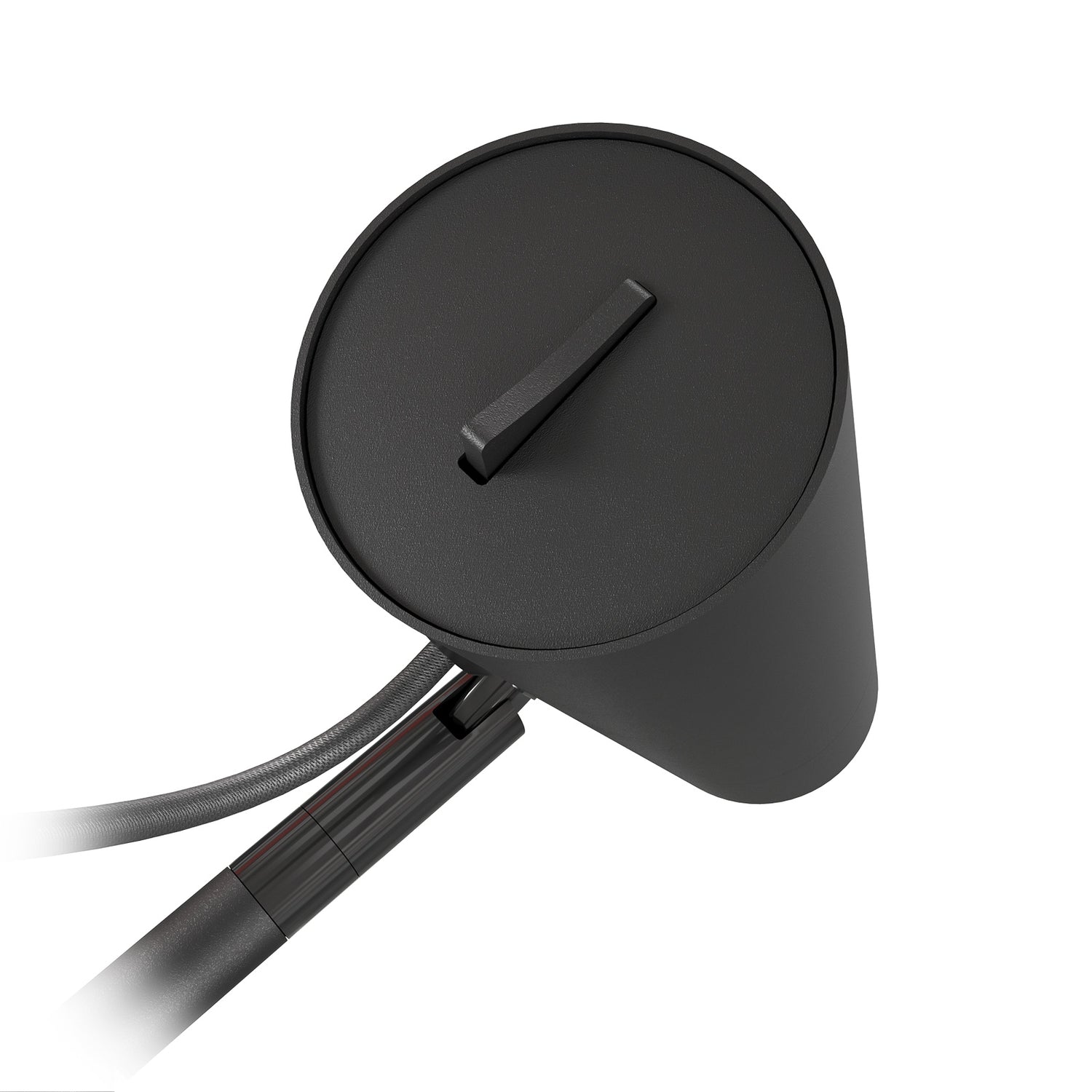 Kuvassa on Spot-lattiavalaisimen spottivalon tausta mattamustana. Valon virtakytkin on spottikuvun päällä.