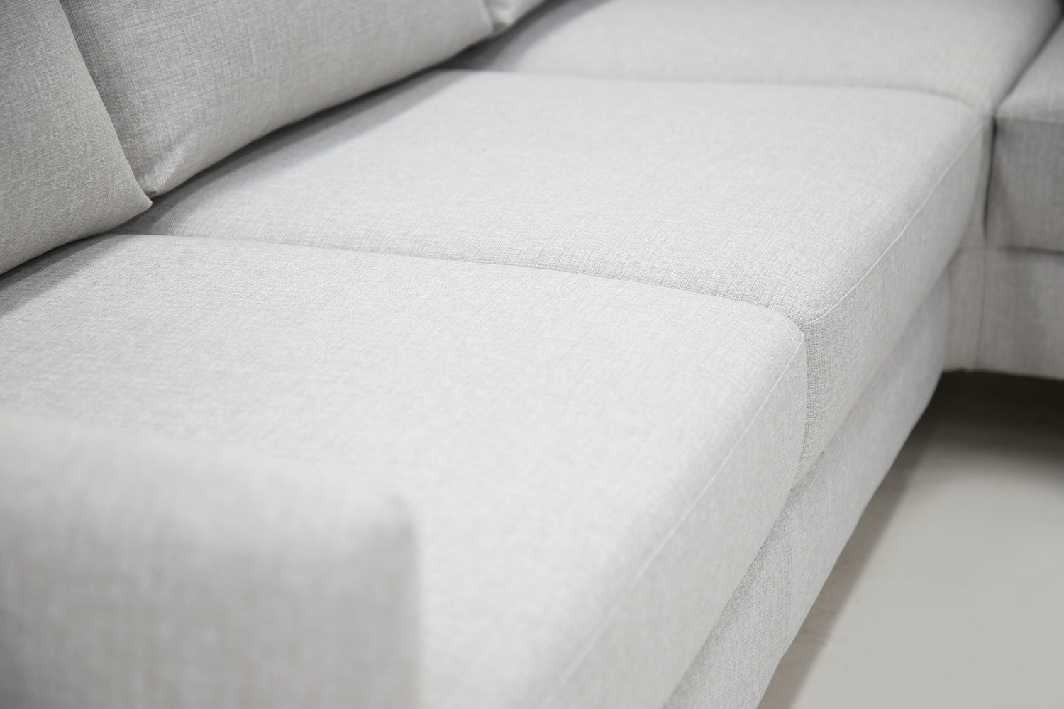 Lähikuva Stockholm-avokulmavuodesohvan vaaleanharmaasta Stark 607 -verhoilusta ja oikeanpuoleisesta kulmasta.