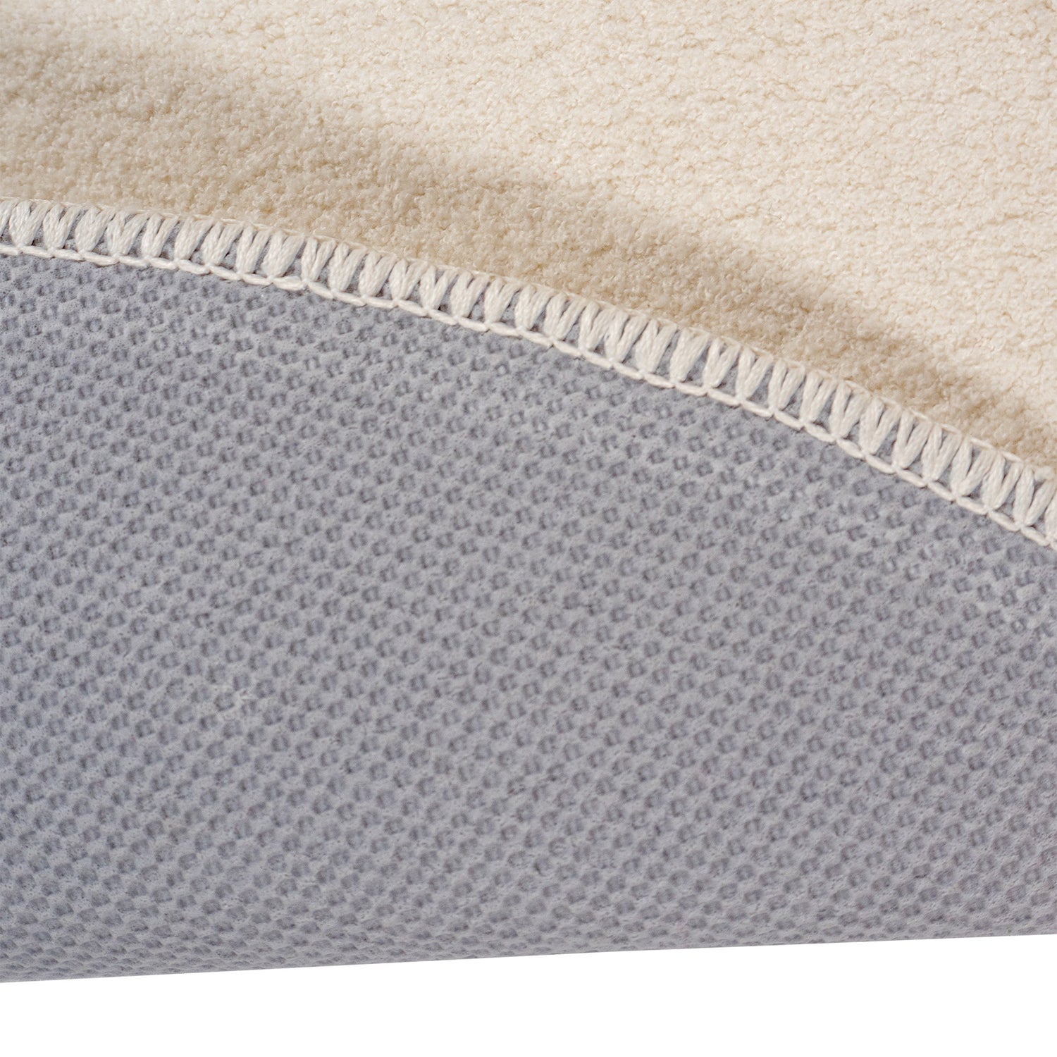Pyöreä Usva-matto valkoisena. Lähikuvassa nukkamaton liukumaton lateksipohja.