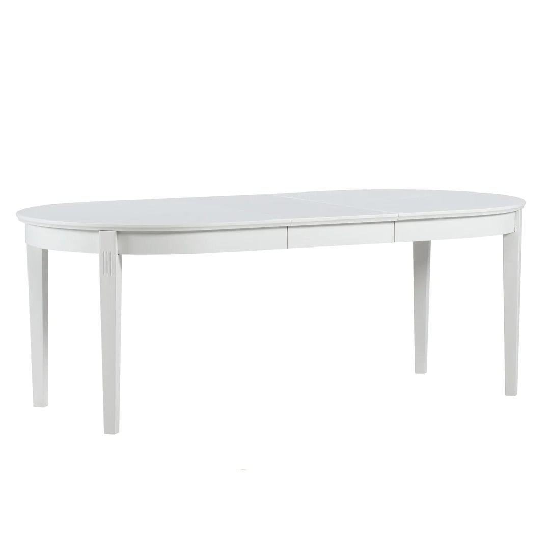 Kokonaan valkoinen ovaalinmuotoinen Kanerva-ruokapöytä jatkettuna.