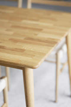 Lähikuvassa Tyler-pöydän luonnonväristä tammipintaa ja jalkoja.