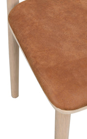 Wolcott- ruokapöydän tuoli valkotammen värisellä rungolla ja ruskealla kangasverhoilulla.