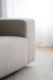 Lähikuvassa on Willard-kulmasohvan vaalean beige Alice 01 -kangasverhoilu ja mustat matalat jalat.