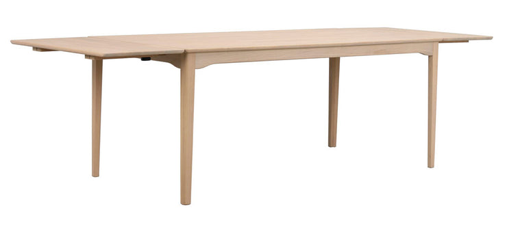 Kuvassa on valkotammenvärinen Markham-ruokapöytä 180 x 90 cm, joka on jatkettu molemmista päistä 45 cm jatkopaloilla 270 cm mittaan.