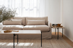 Kuvassa on valkotammenvärinen Shelton-sohvapöydät etualalla isompi ja sivussa pienempi, taustalla Rowicon Payton-sohva.