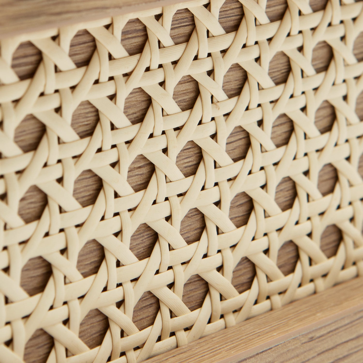 Lähikuvassa luonnontammenvärisen Pensacola-sohvapöydän polyrottinki, joka on molemminpuolisten laatikoiden etulevyissä yksityiskohtana.