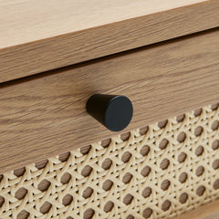 Lähikuvassa Pensacola-sohvapöytä, luonnonvärinen tammi. Sohvapöydän molemminpuolisten laatikoiden etulevyissä on yksityiskohtana polyrottinki. Mustat metallijalat.