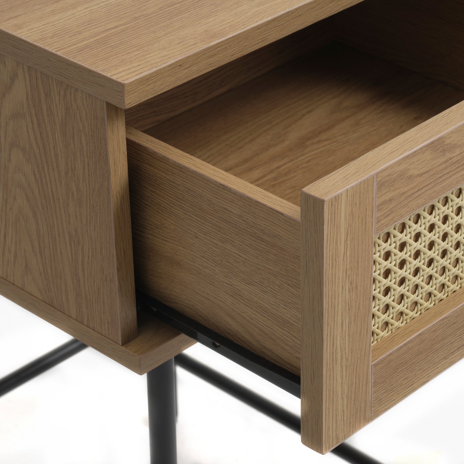 Lähikuvassa Pensacola-yöpöytä/sivutaso, luonnonvärinen tammi. Pikkutason laatikon
etulevyssä on yksityiskohtana polyrottinki. Mustat metallijalat.