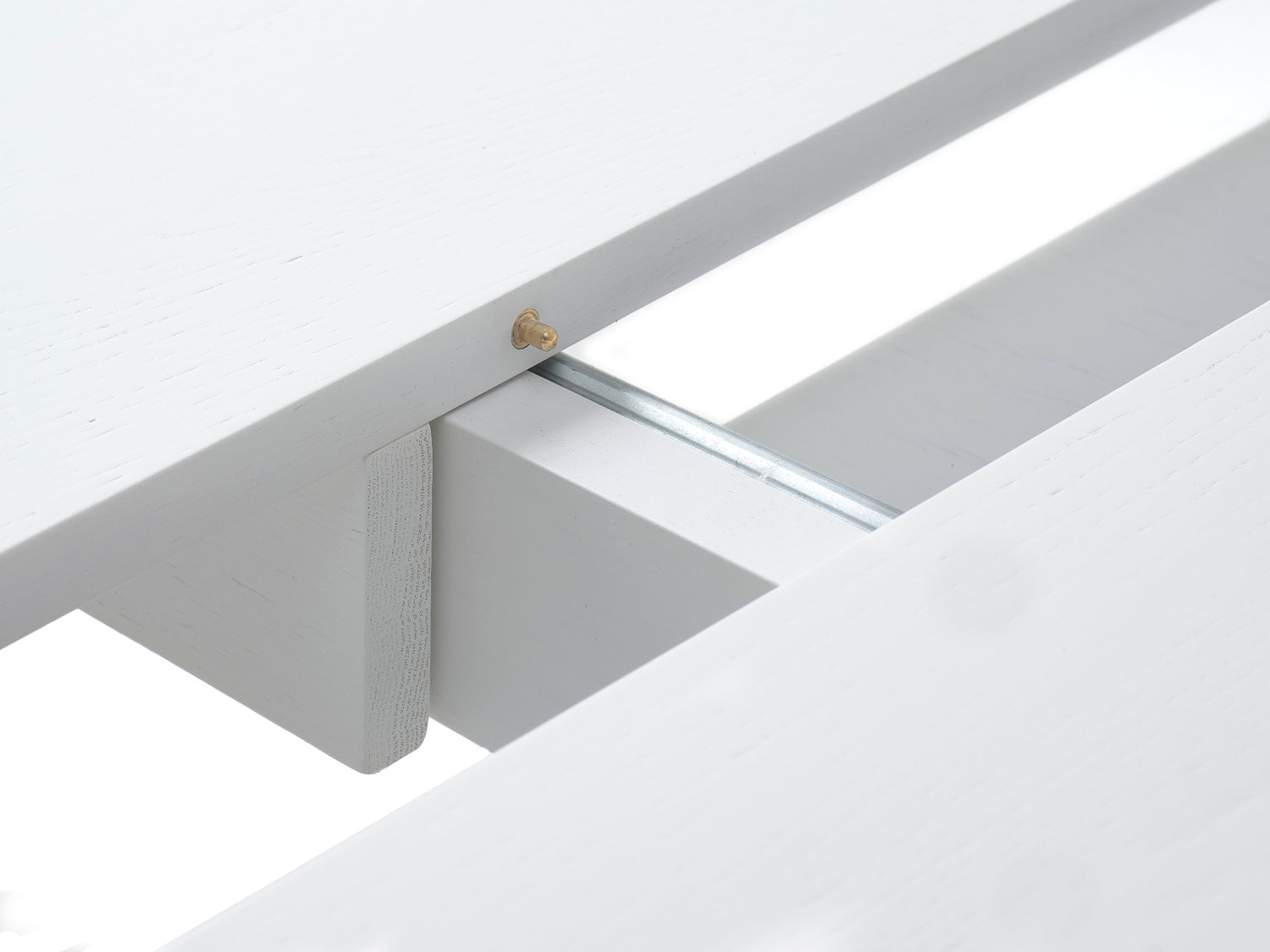 Jatkettava 120 cm Nola-ruokapöytä jatketaan keskeltä pöytää, jossa jatkopaloja säilytetään kannen alla.