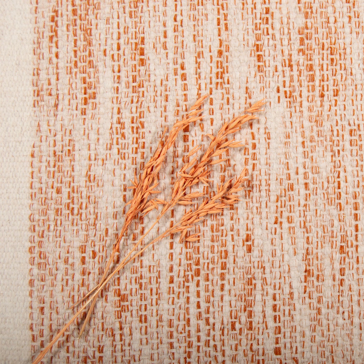 Aamu-villamatto, terra väri ja kuvassa on maton päällä koristetähkä.