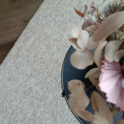 Kuvassa on beige-harmaa sileäpintainen Ahto-matto kuvattuna sohvapöydän alla.