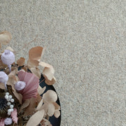 Kuvassa on beige-harmaa sileäpintainen Ahto-matto kuvattuna sohvapöydän alla.