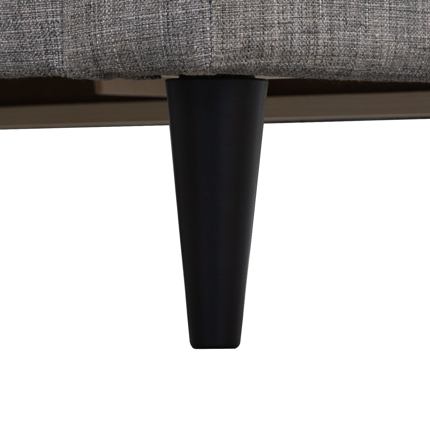 Lähikuvassa Ancona-sohvan musta puujalka.