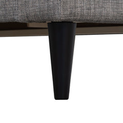 Lähikuvassa Ancona-sohvan musta puujalka.