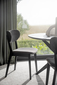 Kuvassa on Kato-taivutetuoli mustana, tummanharmailla istuimen ja selkänojan kangasverhoiluilla sekä Calverton-pöytä (myydään erikseen).