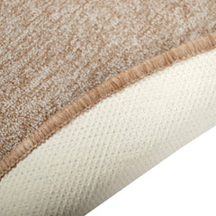 Lähikuvassa pyöreän Carina-maton reunausta ja pohjaa - maton lämmin beige sävy, joka sisältää kevyttä meleerausta. 