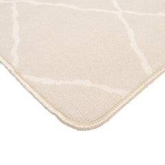 Lähikuvassa bukleepintainen Carlos-matto, beige valkoisilla salmiakkikuvioilla.