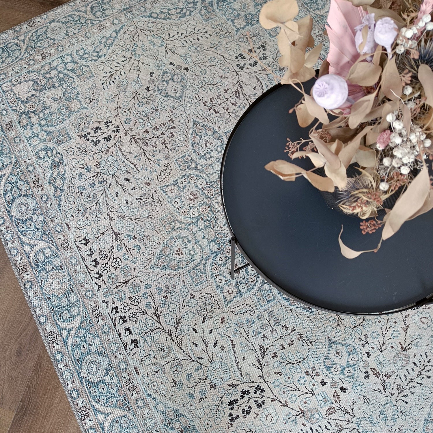 Kuvassa on Cecilia-maton beige-sinisen sävyinen itämainen kuosi kuvattuna sohvapöydän alla.
