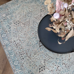 Kuvassa on Cecilia-maton beige-sinisen sävyinen itämainen kuosi kuvattuna sohvapöydän alla.