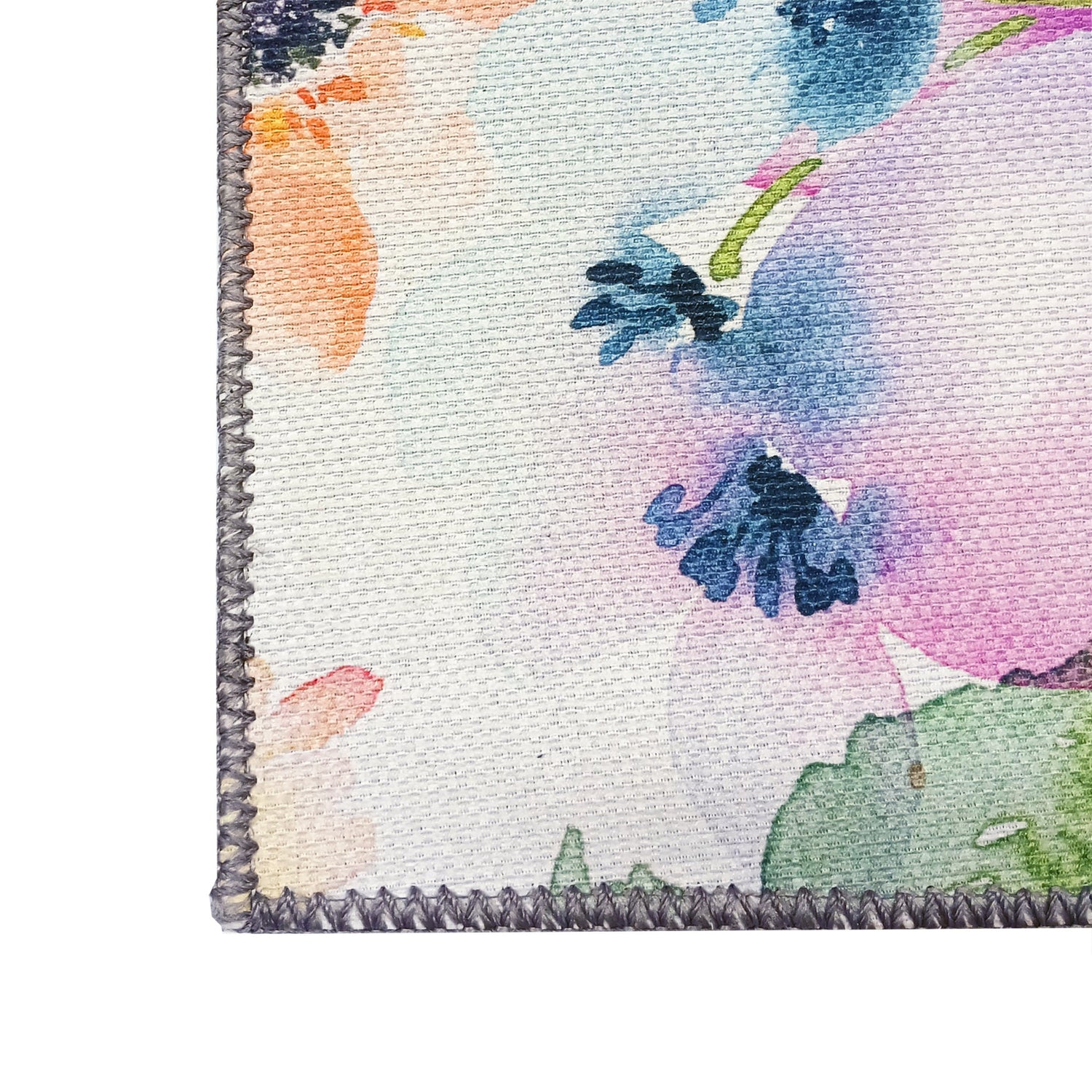 Lähikuvassa Daisy-kukkamaton värikästä violetin sävyistä pintaa ja reunan lankakanttausviimeistelyä.