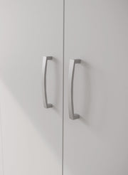 Lähikuvassa kokovalkoisen 3-ovisen Kira-komeron tuplaovikaapin hopeanharmaat vetimet.