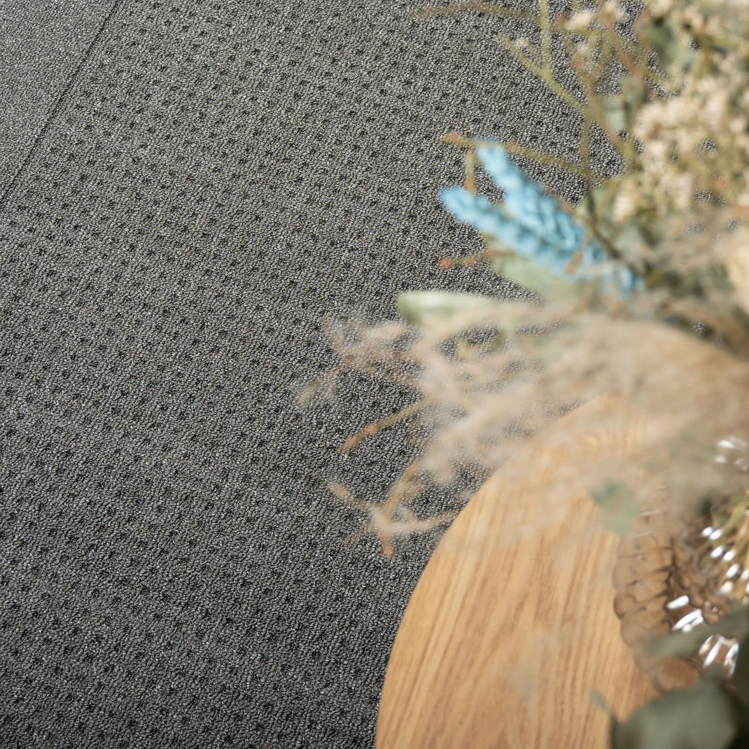 Kuvassa on sohvapöydän alla kuvattuna sileäksi kudottu Fanni-matto, harmaa. 
