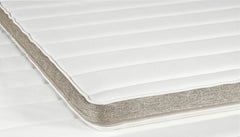 Profiloidun Havu-sijauspatjan reunassa on sängyn rungon värinen hiekanvärinen boordi. Petauspatjan makuupinnoilla on valkoinen joustoneulos.