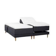 Antrasiitinväriset Hilding Cross -moottorisängyt tammenvärisillä Hilding Raita -tammijaloilla, erillisillä Hilding Ergo -sijauspatjoilla ja Hilding -tarviketaskulla.