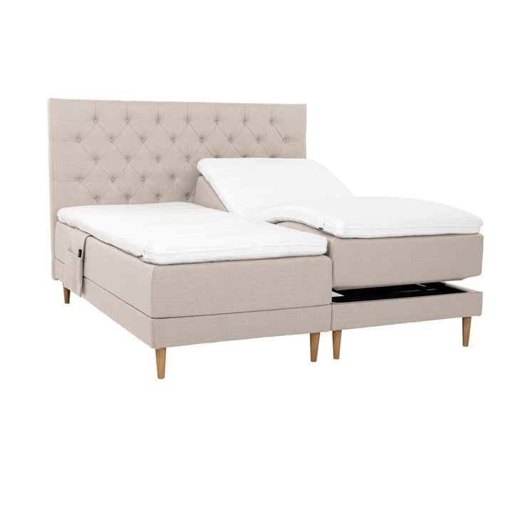 Beiget Hilding Cross -moottorisängyt tammenvärisillä Hilding Raita -tammijaloilla, erillisillä Hilding Ergo -sijauspatjoilla ja Hilding -tarviketaskulla. Kuvan Cross -sängynpääty myydään erikseen.