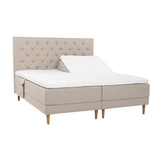 Beiget Hilding Cross -moottorisängyt tammenvärisillä korkeilla Hilding Raita -tammijaloilla, erillisillä Hilding Ergo -sijauspatjoilla ja Hilding -tarviketaskulla. Kuvan Cross -sängynpääty myydään erikseen.