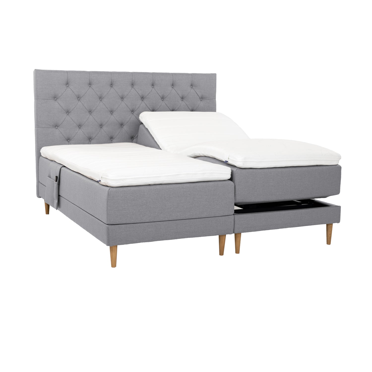 Harmaat Hilding Cross -moottorisängyt tammenvärisillä Hilding Raita -tammijaloilla, erillisillä Hilding Ergo -sijauspatjoilla ja Hilding -tarviketaskulla. Kuvan Cross -sängynpääty myydään erikseen.