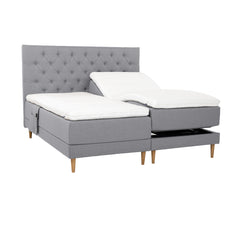 Harmaat Hilding Cross -moottorisängyt tammenvärisillä Hilding Raita -tammijaloilla, erillisillä Hilding Ergo -sijauspatjoilla ja Hilding -tarviketaskulla. Kuvan Cross -sängynpääty myydään erikseen.