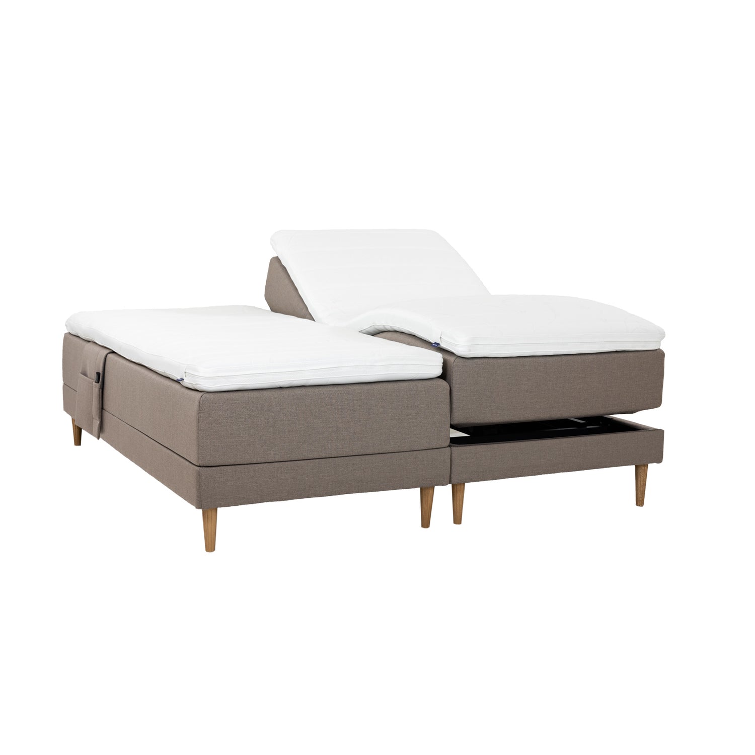 Hiekanväriset Hilding Cross -moottorisängyt tammenvärisillä Hilding Raita -tammijaloilla, erillisillä Hilding Ergo -sijauspatjoilla ja Hilding -tarviketaskulla.