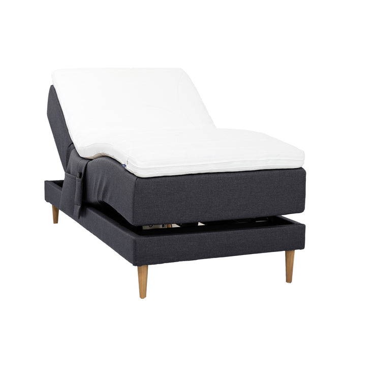 Antrasiitinvärinen Hilding Cross -moottorisänky tammenvärisillä Hilding Raita -tammijaloilla, Hilding Ergo -sijauspatjalla ja Hilding -tarviketaskulla.