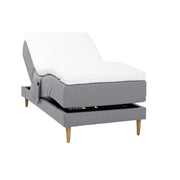 Harmaa Hilding Cross -moottorisänky tammenvärisillä Hilding Raita -tammijaloilla, Hilding Ergo -sijauspatjalla ja Hilding -tarviketaskulla.