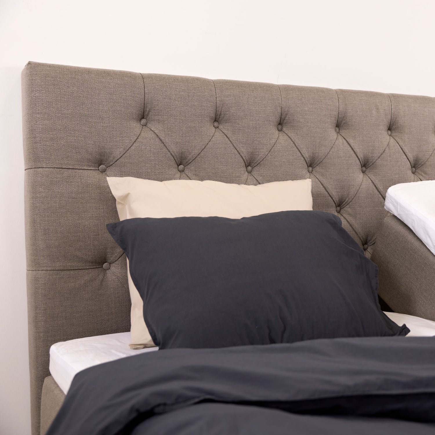 Kuvassa on napillinen Hilding Cross -sängynpääty hiekanvärisenä.