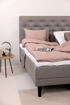 Harmaat Hilding Feel -moottorisängyt hiilenmustilla Royal -tammijaloilla. Kuvan sängyn Feel -sängynpääty ja tarviketasku & petivaatteet myydään erikseen.