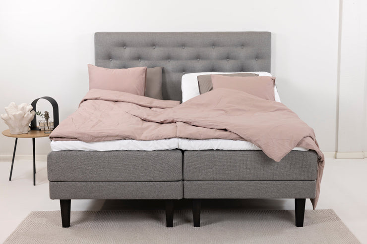 Harmaat Hilding Feel -moottorisängyt hiilenmustilla Royal -tammijaloilla. Kuvan sängyn Feel -sängynpääty ja tarviketasku & petivaatteet myydään erikseen.