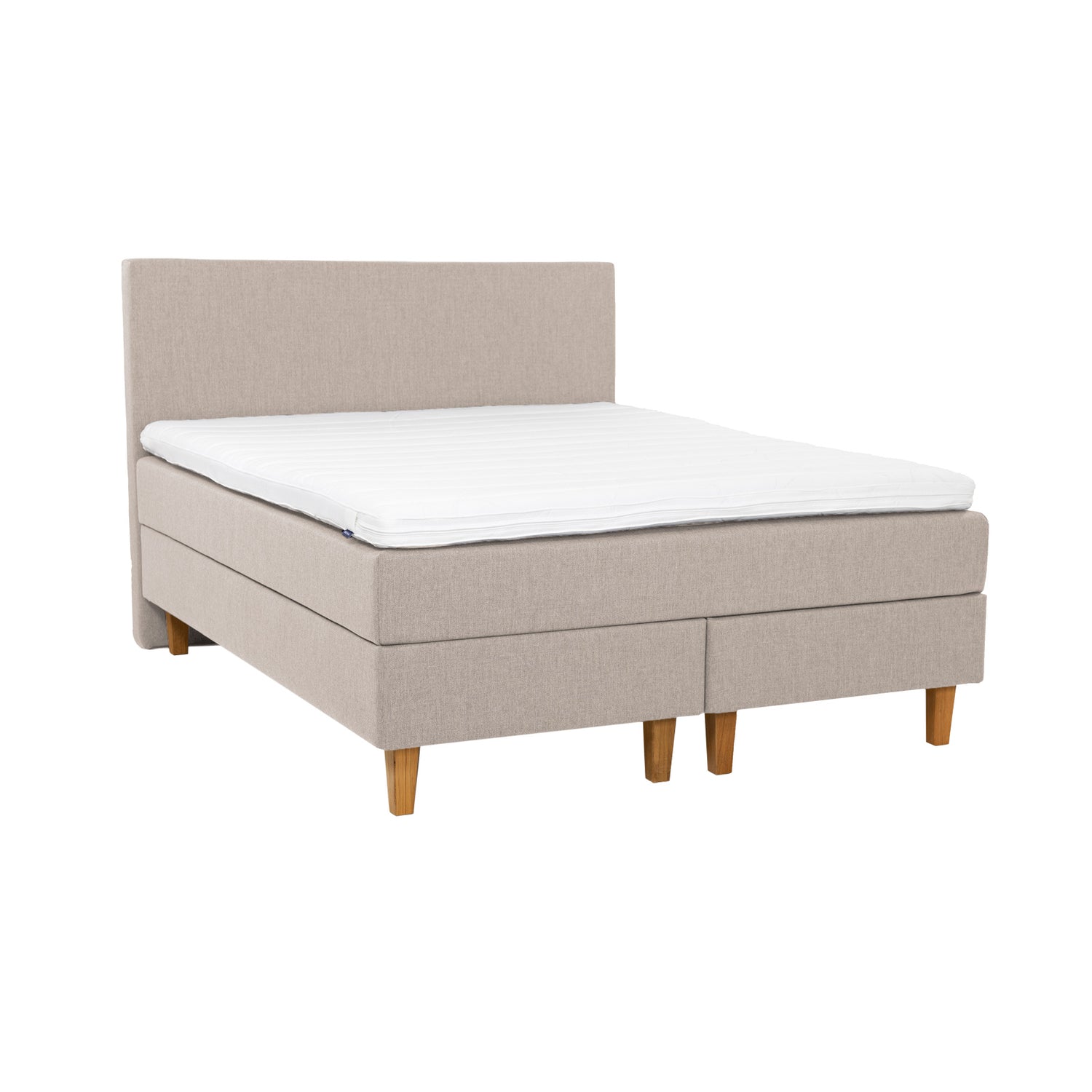 Beigenvärinen Hilding Original -jenkkisänky luonnonvärisillä 18 cm korkeilla Royal-tammijaloilla ja yhtenäisellä profiloidulla kimmovaahtosijauspatjalla. Kuvan sängynpääty myydään erikseen.