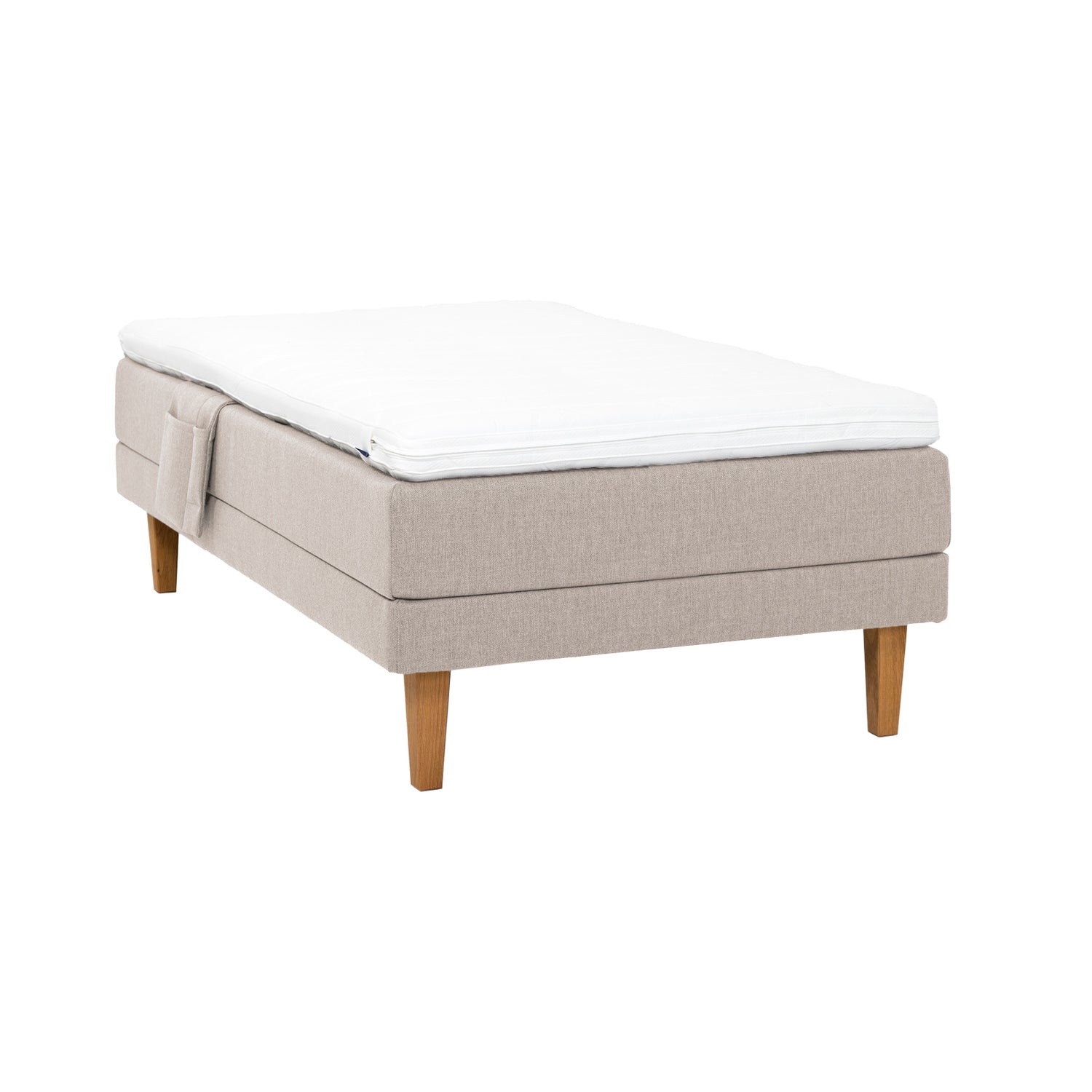 Beige Hilding Original -moottorisänky luonnonvärisillä 23 cm korkeilla Royal -tammijaloilla ja profiloidulla kimmovaahtosijauspatjalla. Kuvan tarviketasku myydään erikseen.