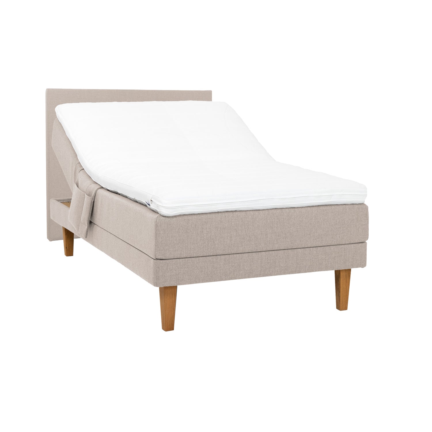 Beige Hilding Original -moottorisänky luonnonvärisillä 23 cm korkeilla Royal -tammijaloilla ja profiloidulla kimmovaahtosijauspatjalla. Kuvan sängynpääty ja tarviketasku myydään erikseen.