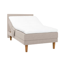 Beige Hilding Original -moottorisänky luonnonvärisillä 23 cm korkeilla Royal -tammijaloilla ja profiloidulla kimmovaahtosijauspatjalla. Kuvan sängynpääty ja tarviketasku myydään erikseen.
